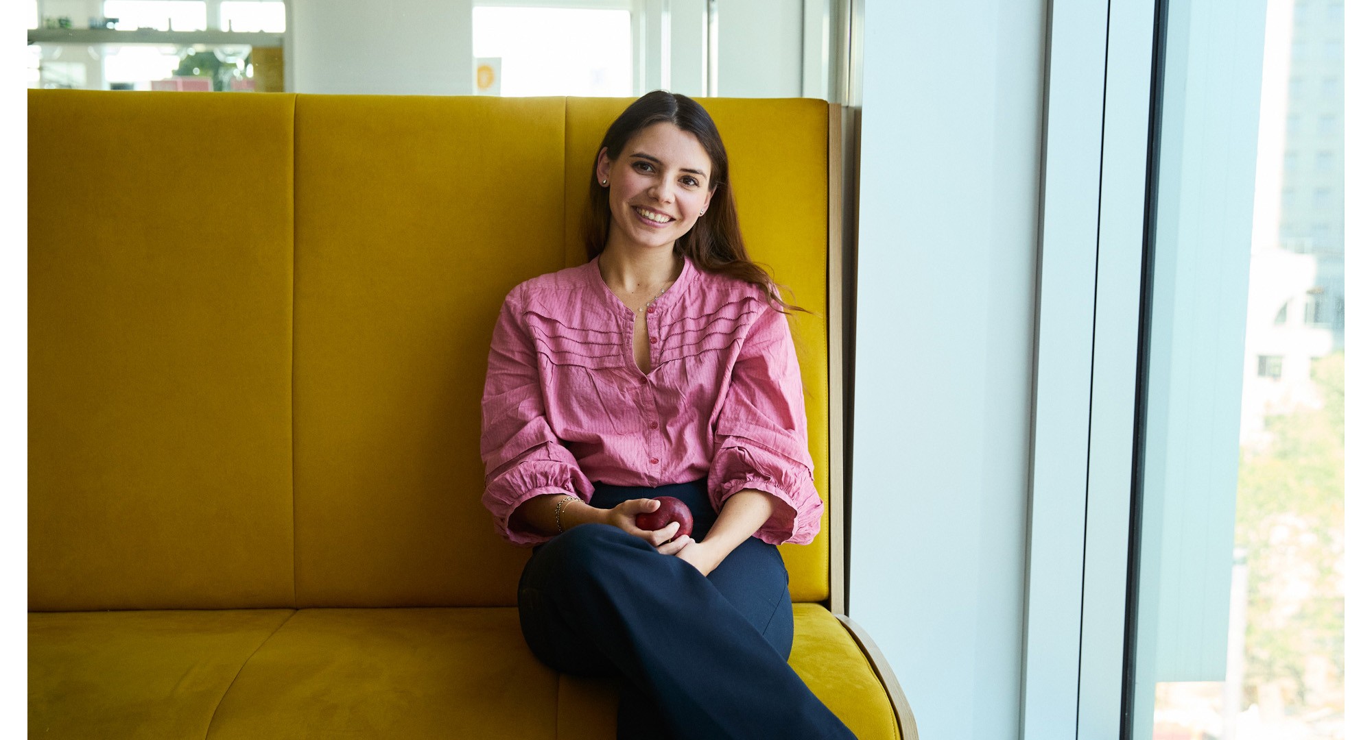 En af vores kolleger knæler på en stol og taler om, hvad det betyder at arbejde hos Novo Nordisk