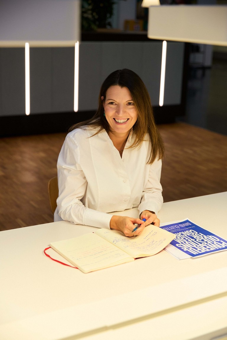 Cristina sitting with her note book smiling