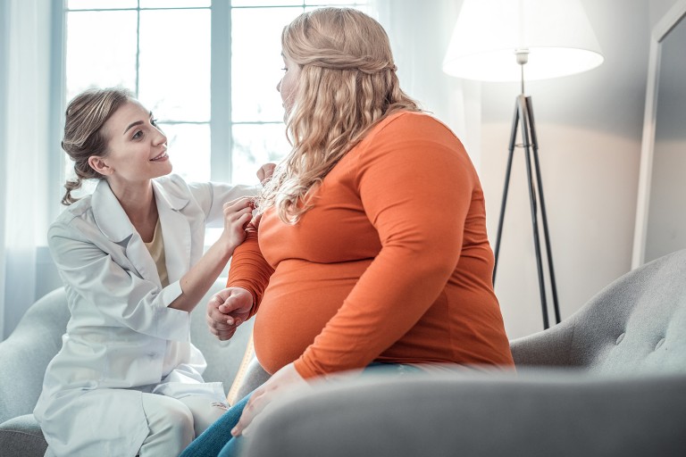  An overweight patient with a young, cheerful doctor at a checkup