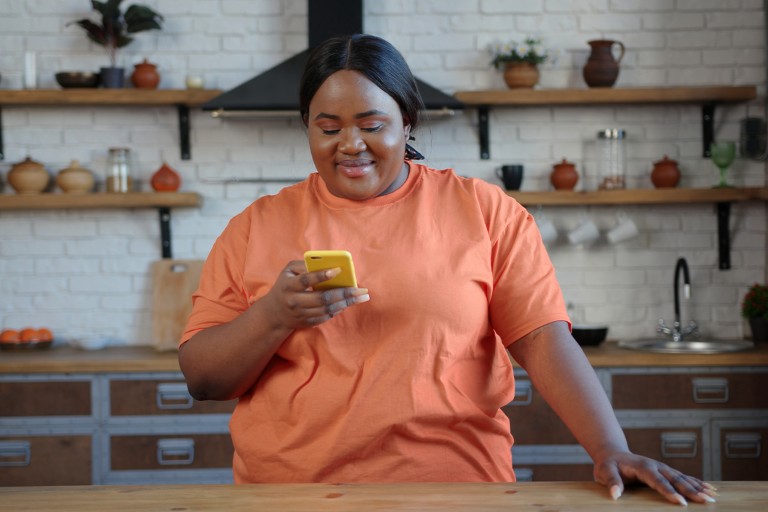 An obese woman scrolls through her phone to find a doctor