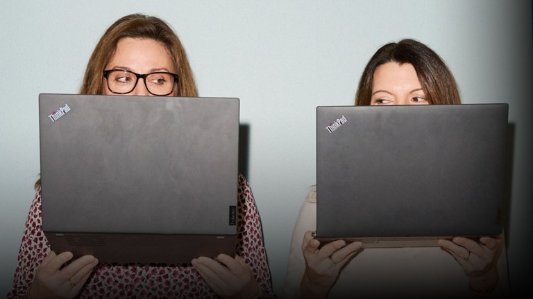 Image of two people looking into their laptop computers