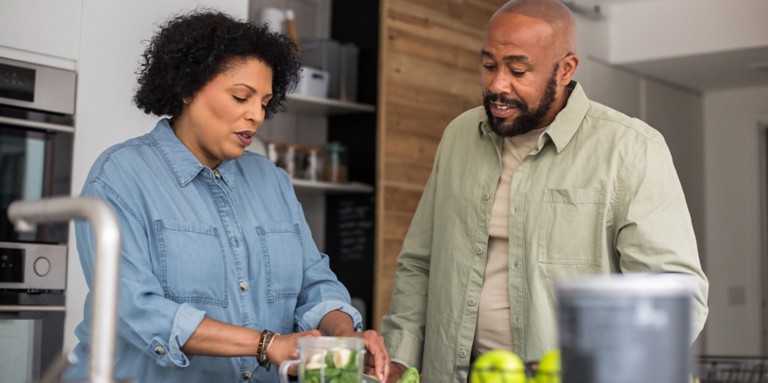 A couple prepares a healthy smoothy in the kitchen