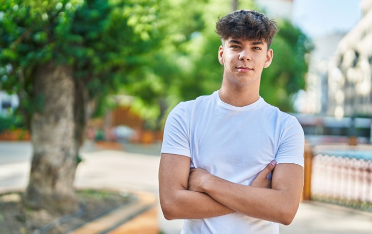 Young man standing with his arms folded
