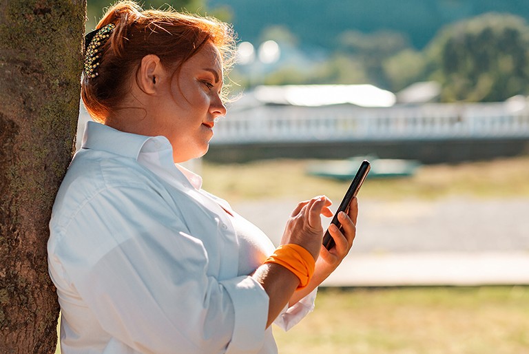 An obese woman explores options on her phone