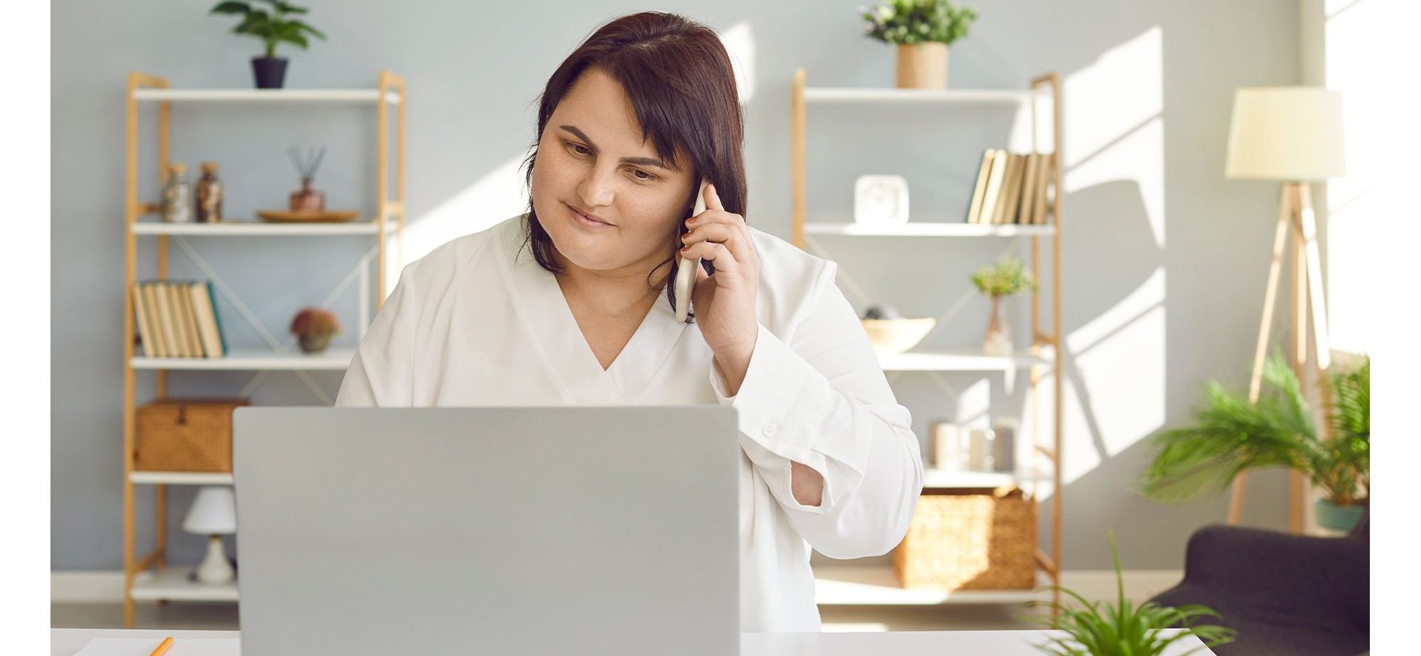 Business woman working on her computer and phone