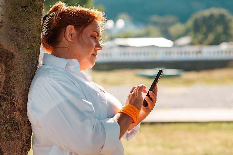 An obese woman explores options on her phone