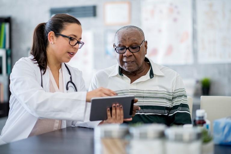 A doctor provides information on obesity care to an older patient of color