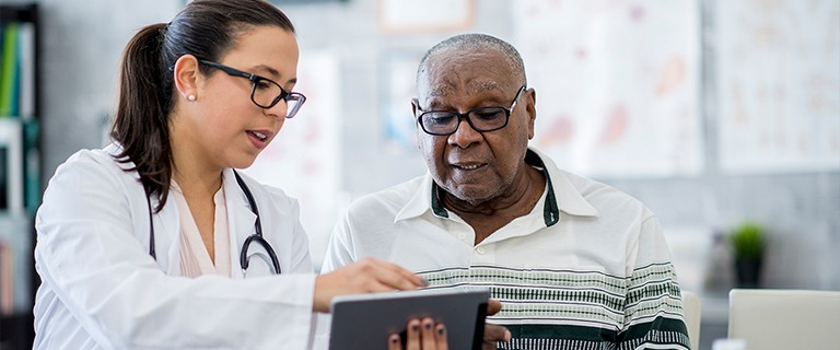 A doctor provides information on obesity care to an older patient of color
