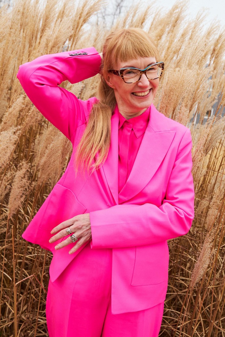 Novo Nordisk scientist standing in front of a field with tall grass behind her