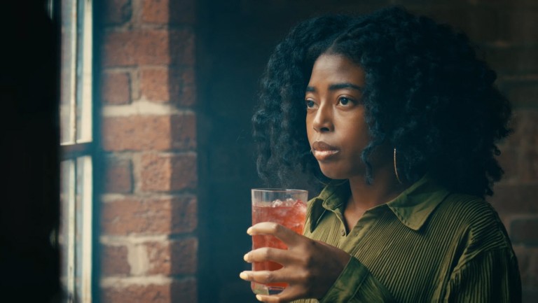Woman drinking a beverage by the window 