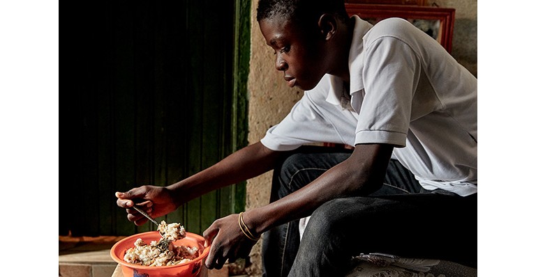 Trésor Kouadio, who living with type 1 diabetes in the Ivory Coast, is eating his lunch.