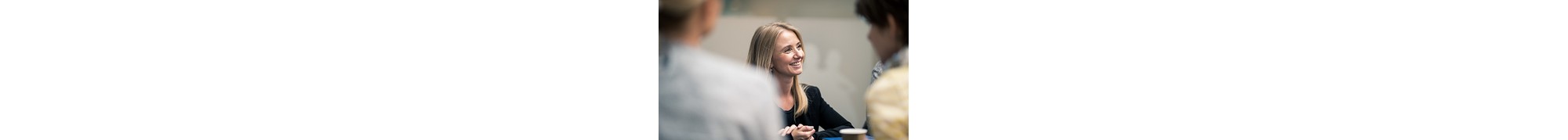 One of our colleagues kneeling on a chair and talking about what it means for them to work at Novo Nordisk
