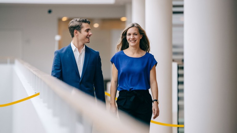 Two colleagues walking through the office space