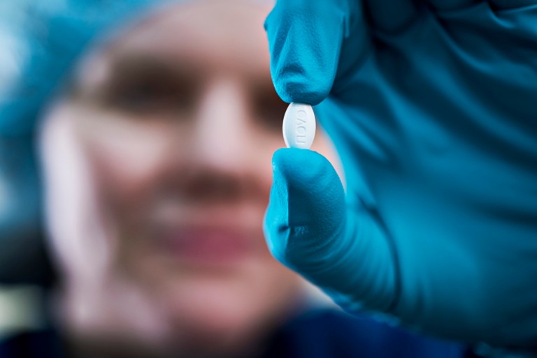 Our scientific approach, Novo Nordisk employee holding a pill.