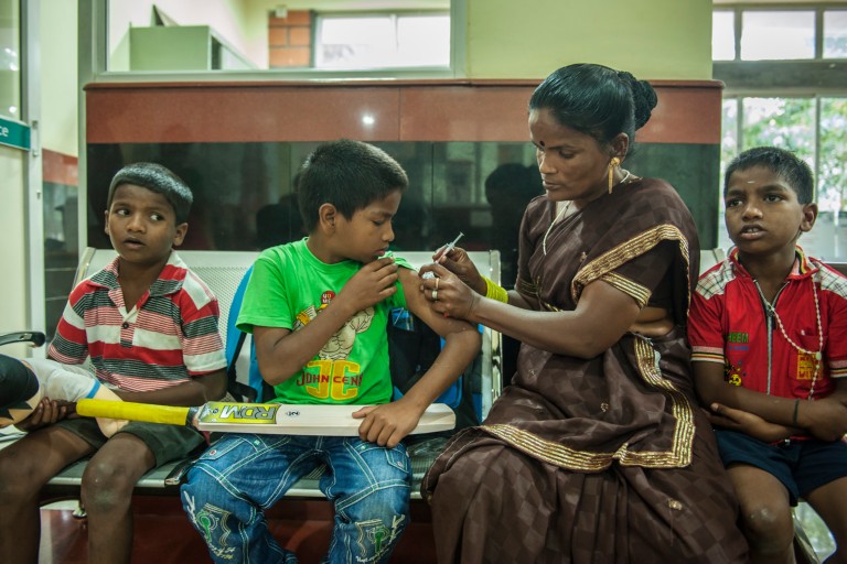 Barn og en kvinne i Bangalore i India som sitter.