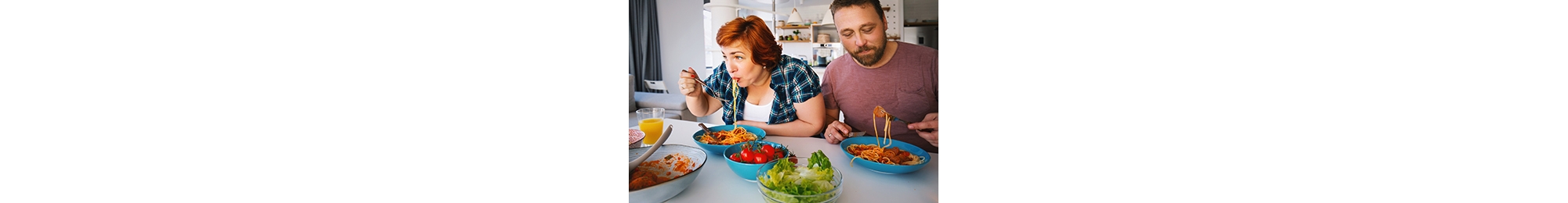Overweight mid adult couple eating lunch at home.