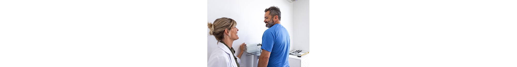 Argentinean nutritionist woman controlling height, weight and  mesures to her overweight man patient in her office. She uses a professional scale and mesuring tape to calculate body mass index. Buenos Aires - Argentina